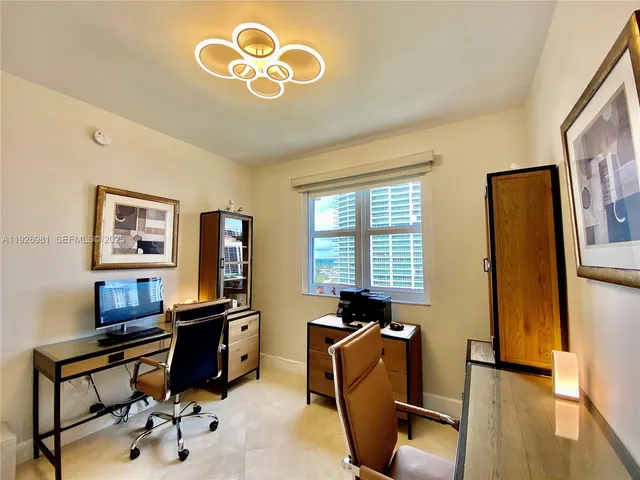 a view of a workspace with furniture and a window