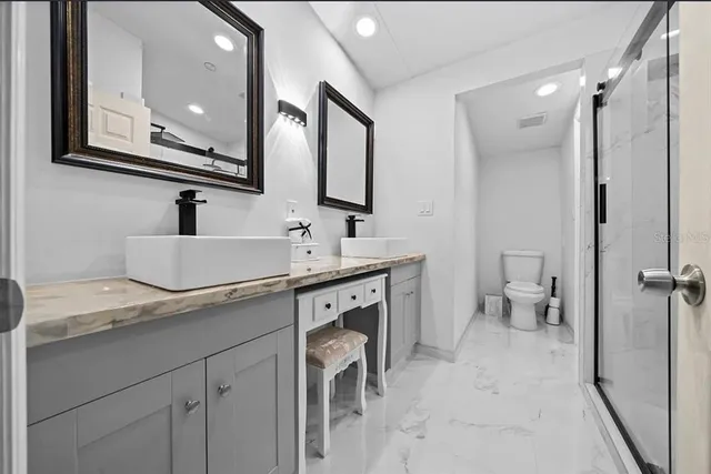 a bathroom with a double vanity sink mirror and toilet