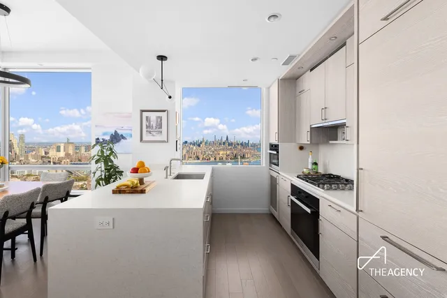 a kitchen that has a lot of cabinets in it and wooden floors