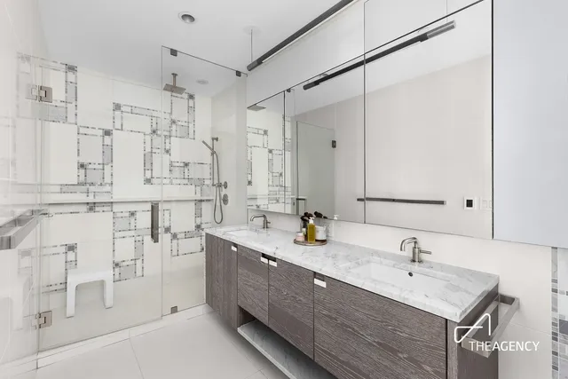 a bedroom with a bed a couch and a flat tv screen next to a window