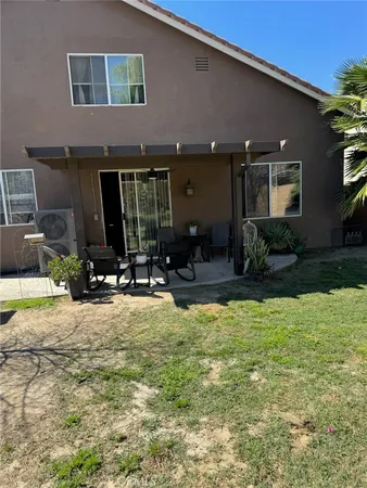 a view of a house with backyard and sitting area