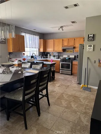 a kitchen with a sink a stove a refrigerator and chairs