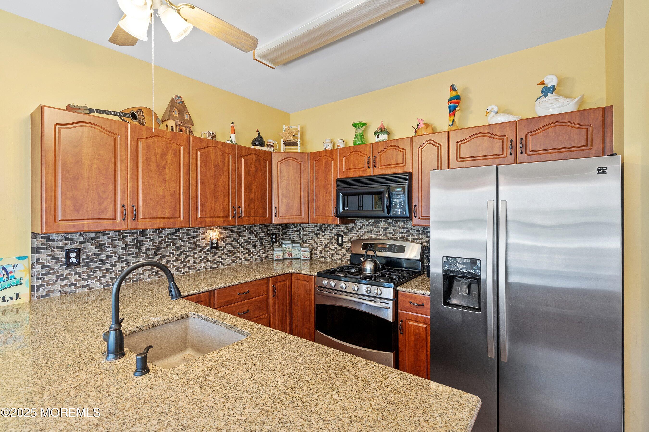10 Hampton Road Manahawkin, NJ 08050 - Photo 6 of 38 a kitchen with granite countertop a sink stainless steel appliances and a counter top space
