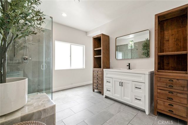 a spacious bathroom with a double vanity sink a mirror and a shower