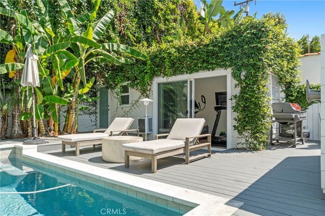 a view of a patio with table and chairs and potted plants with wooden floor and fence