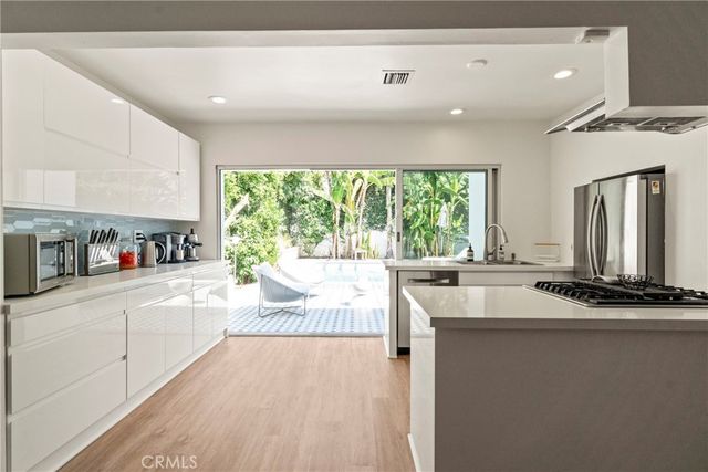 a kitchen with kitchen island granite countertop a sink and a stove top oven