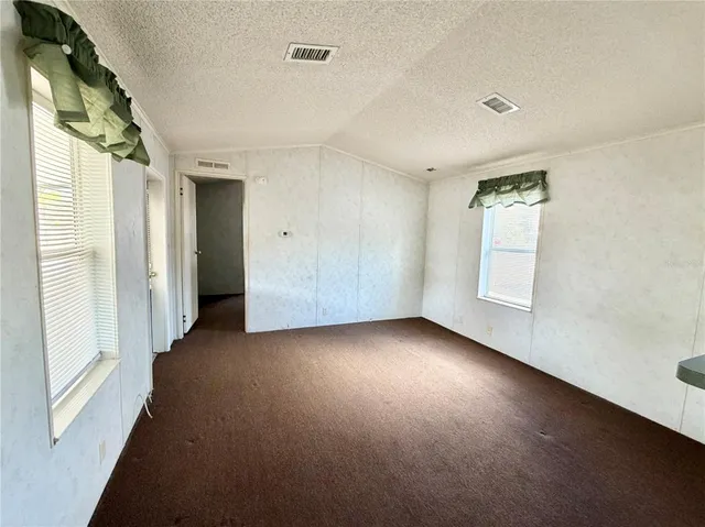 an empty room with windows and closet