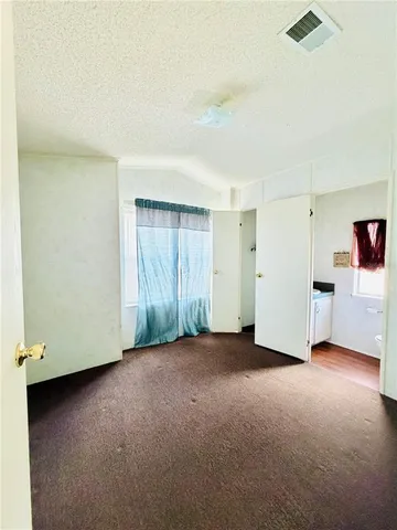 a view of an empty room with a kitchen