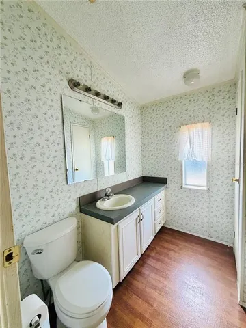 a bathroom with a granite countertop toilet sink and mirror