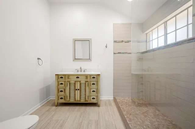 a bathroom with a granite countertop sink toilet and shower