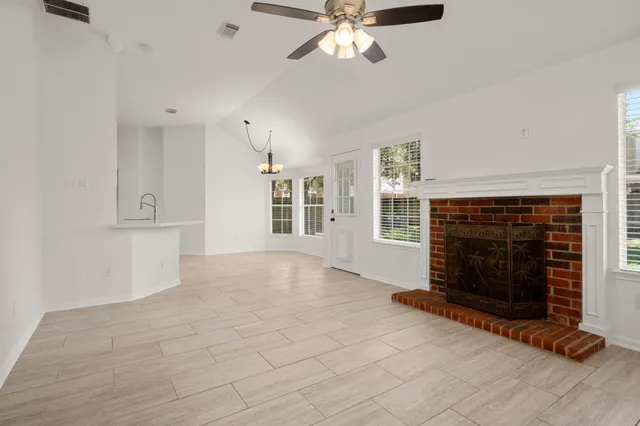 an empty room with windows and fireplace
