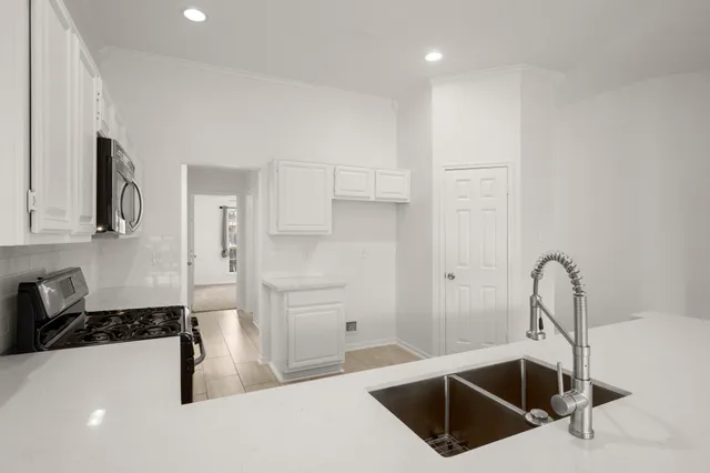 a kitchen with a sink a stove and cabinets