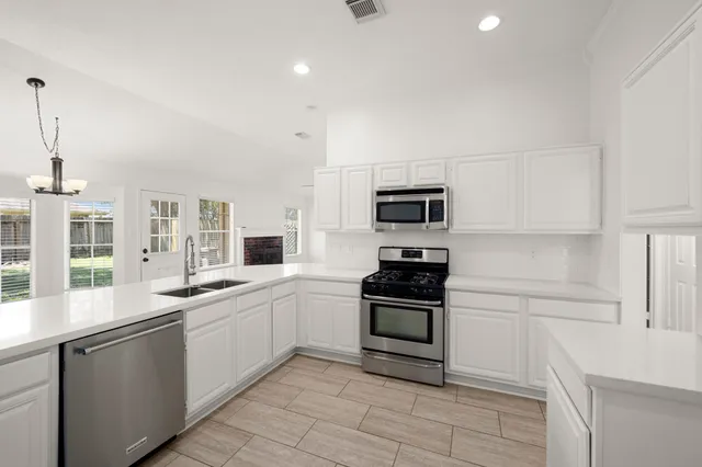 a kitchen with a sink stove and microwave