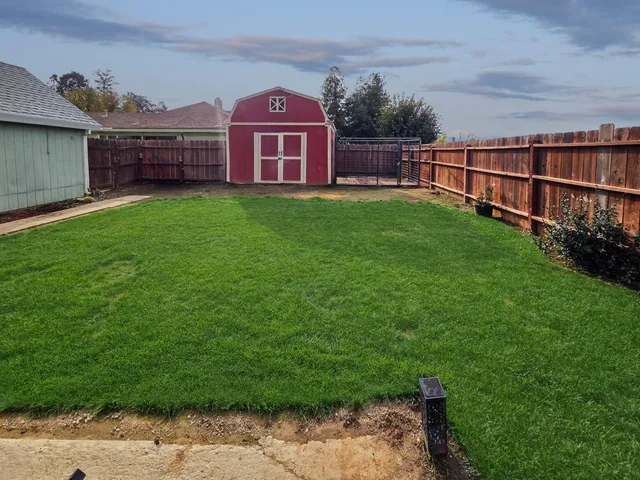 a view of a yard with a small yard and wooden fence