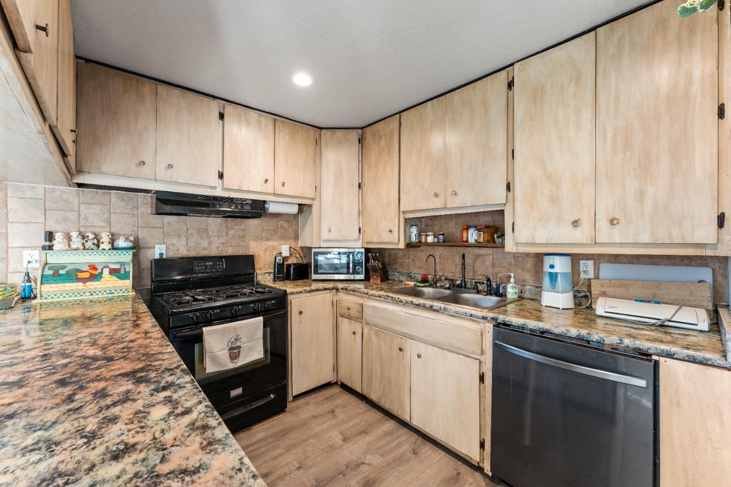 5912 Grove Avenue Marysville, CA 95901 - Photo 7 of 23 a kitchen with stainless steel appliances granite countertop a stove top oven a sink dishwasher and cabinets with wooden floor