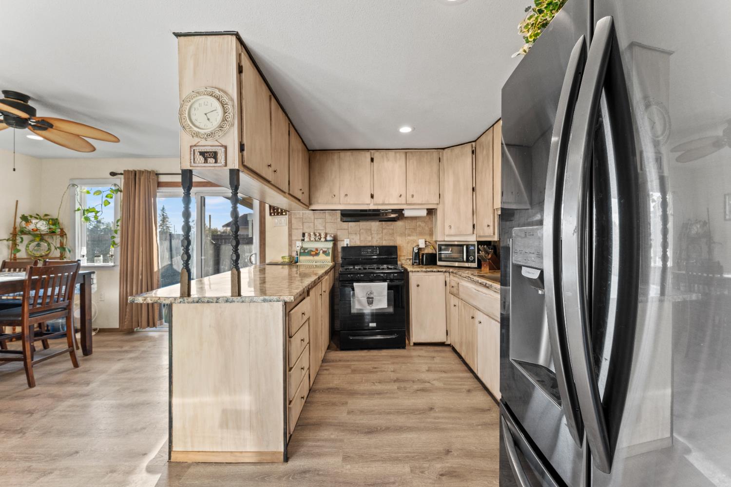 5912 Grove Avenue Marysville, CA 95901 - Photo 8 of 23 a kitchen with stainless steel appliances granite countertop a refrigerator a stove and a sink with wooden floor
