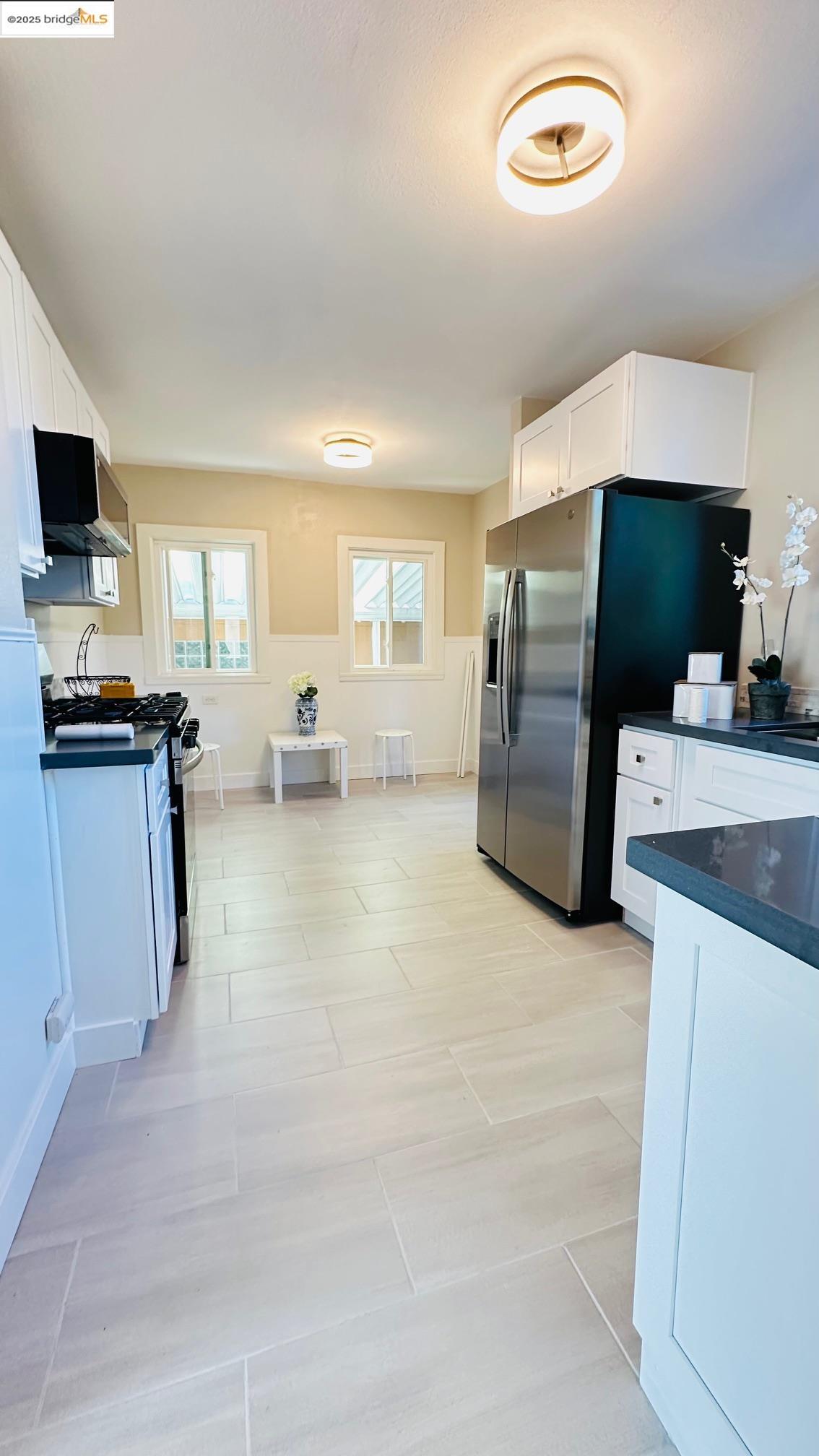 840 Key Rte Boulevard Albany, CA 94706 - Photo 11 of 29 Kitchen featuring white cabinetry, appliances with stainless steel finishes, and light tile patterned floors