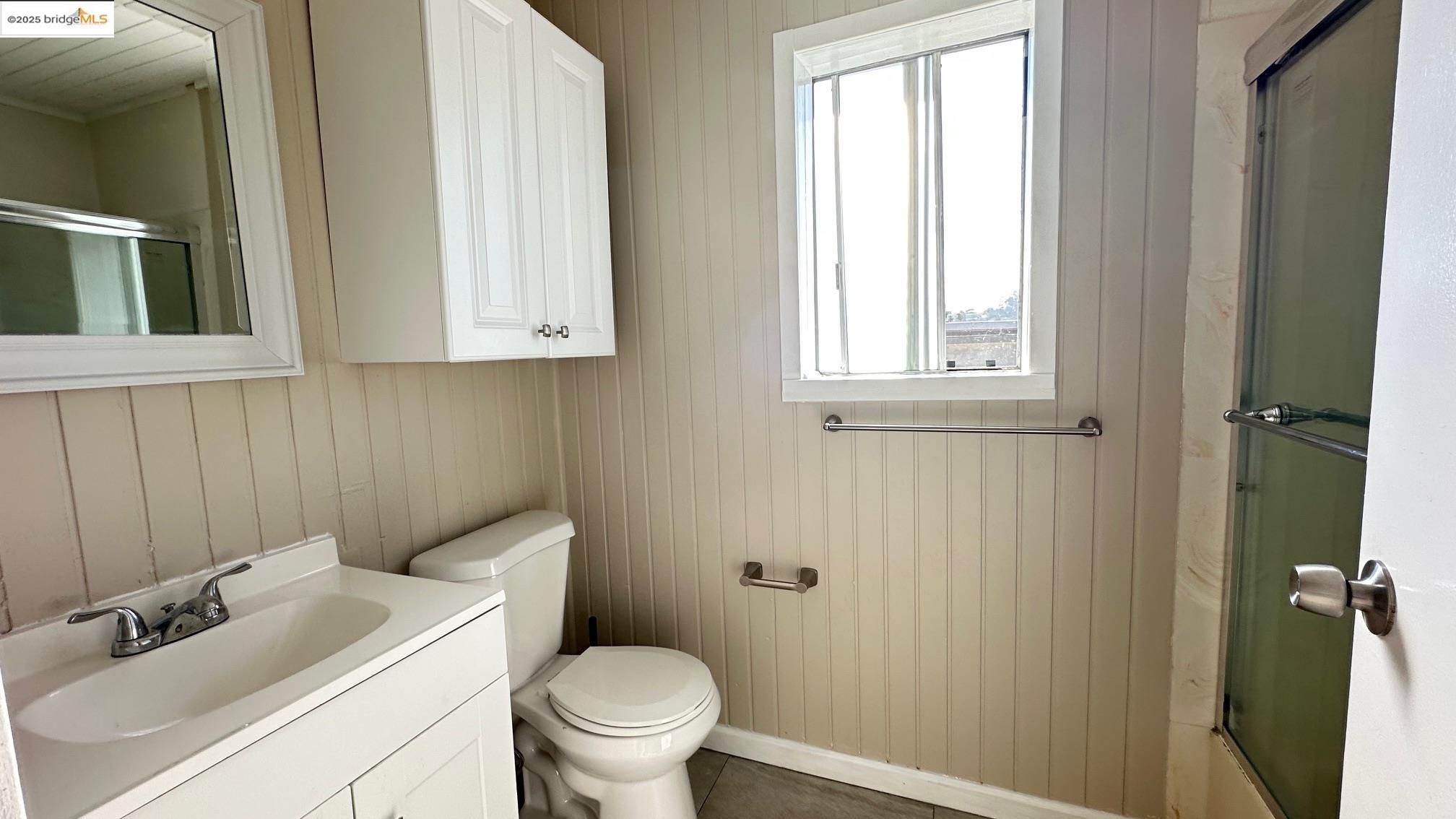 840 Key Rte Boulevard Albany, CA 94706 - Photo 25 of 29 Bathroom featuring vanity, wood walls, and tile patterned floors