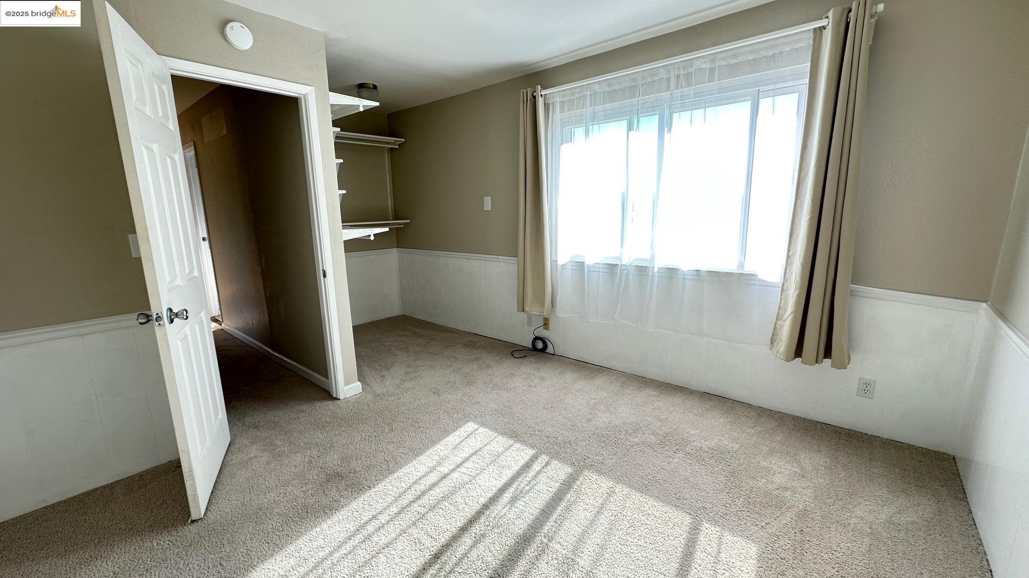 840 Key Rte Boulevard Albany, CA 94706 - Photo 27 of 29 Unfurnished bedroom featuring wainscoting and light colored carpet