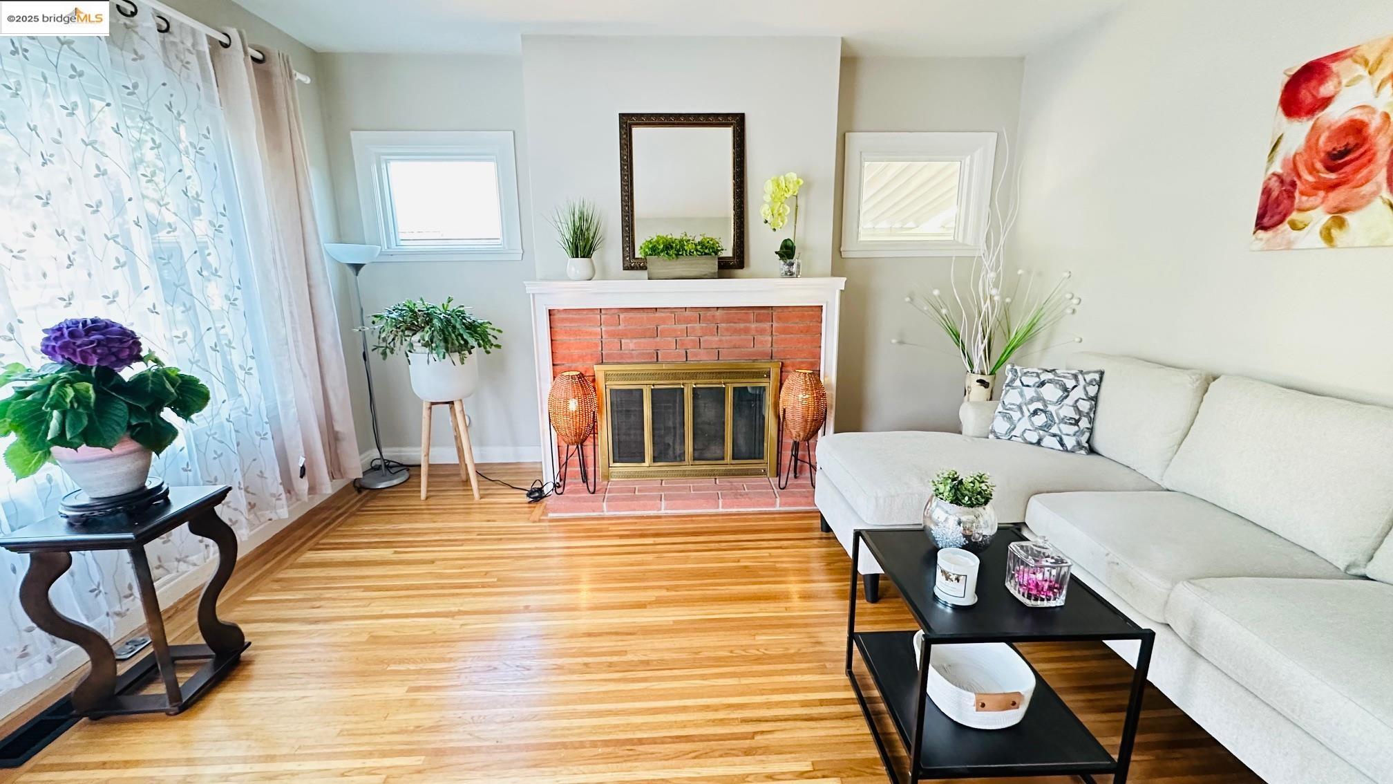 840 Key Rte Boulevard Albany, CA 94706 - Photo 5 of 29 Living area with healthy amount of natural light, wood finished floors, and a brick fireplace