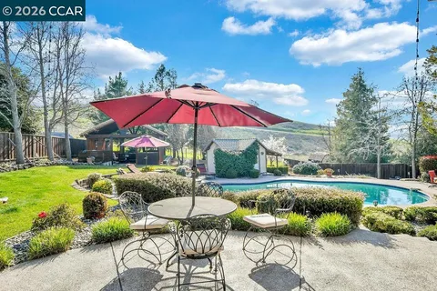 a backyard of a house with table and chairs