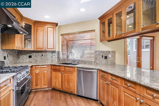 a kitchen with stainless steel appliances granite countertop a sink a stove and a microwave
