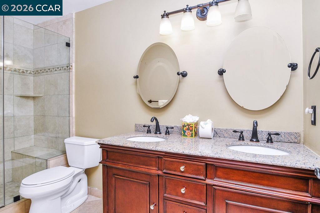 5308 Vista Point Court Concord, CA 94521 - Photo 36 of 56 a bathroom with a granite countertop toilet a sink and a mirror