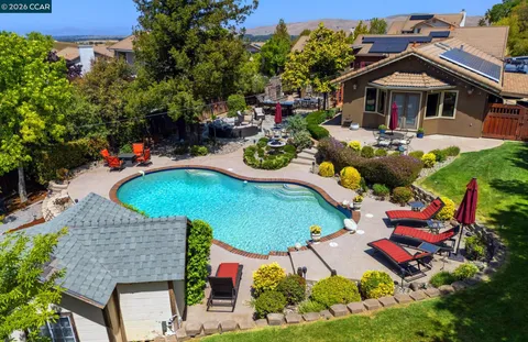 an aerial view of a house with swimming pool and outdoor seating