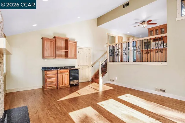 a spacious bedroom with a bed a mirror and a large window