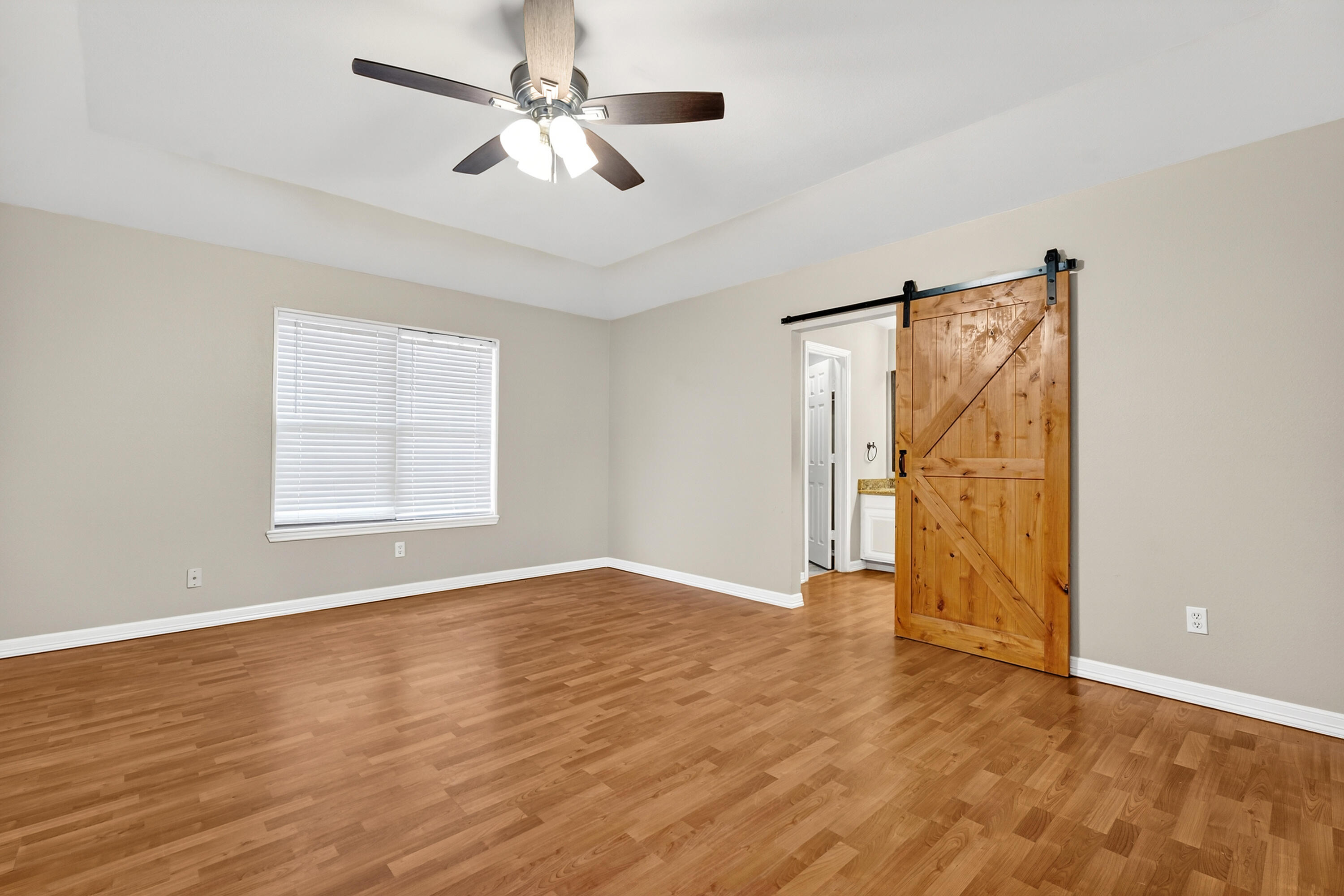 2415 93rd Street Lubbock, TX 79423 - Photo 12 of 24 an empty room with wooden floor chandelier fan and windows