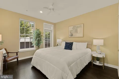 a bedroom with a large bed and wooden floor