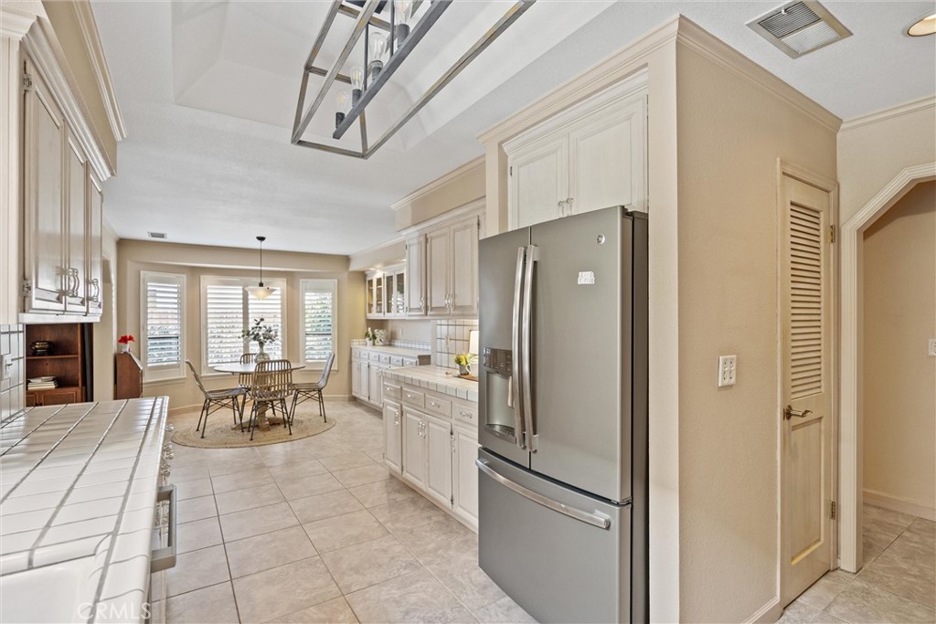 529 Countryside Lane Chico, CA 95973 - Photo 17 of 51 a kitchen with stainless steel appliances granite countertop a refrigerator a stove a dining table and chairs with wooden floor