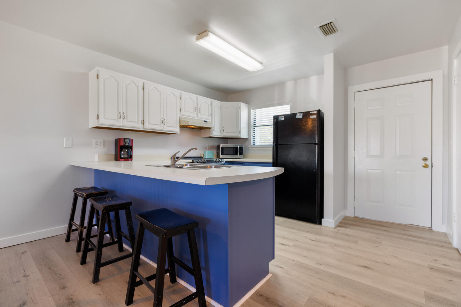 145 Cain Road Panama City Beach, FL 32413 - Photo 21 of 60 a kitchen with a refrigerator a stove a sink cabinets and a dining table