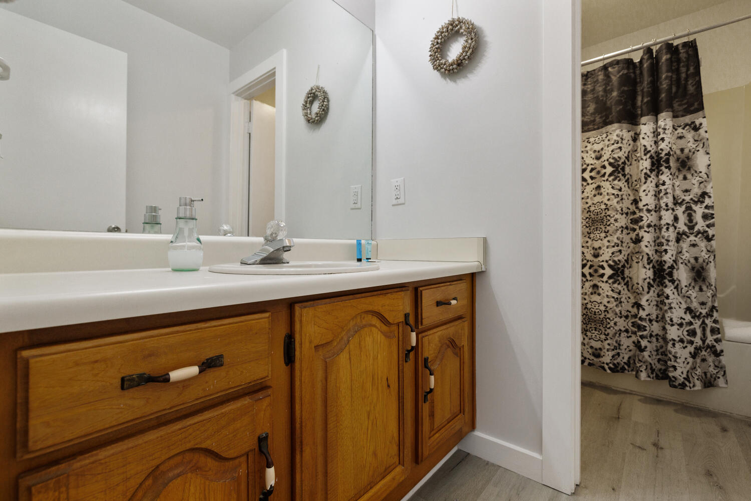 145 Cain Road Panama City Beach, FL 32413 - Photo 28 of 60 a bathroom with a sink a mirror a vanity and shower