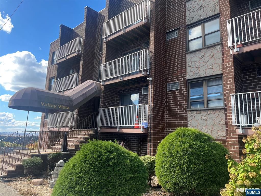 a view of a brick house with many windows and plants