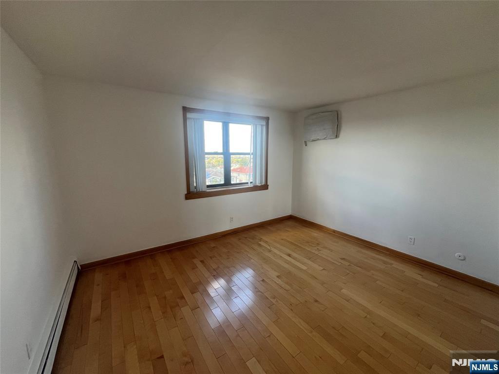 201 12th Street, Unit 6 Palisades Park, NJ 07650 - Photo 12 of 19 an empty room with wooden floor and windows