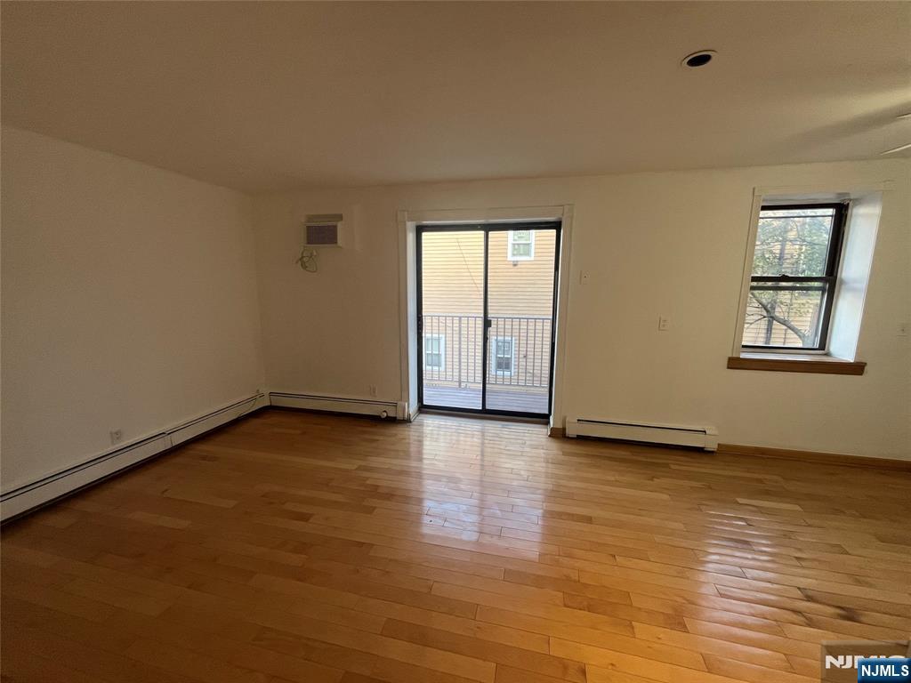201 12th Street, Unit 6 Palisades Park, NJ 07650 - Photo 5 of 19 a view of an empty room with glass door and wooden floor
