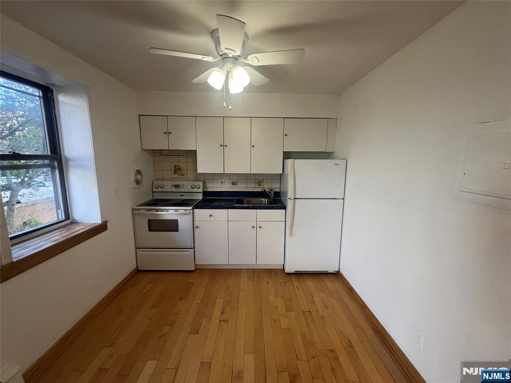 201 12th Street, Unit 6 Palisades Park, NJ 07650 - Photo 7 of 19 a kitchen with stainless steel appliances a white refrigerator a stove a microwave and white walls