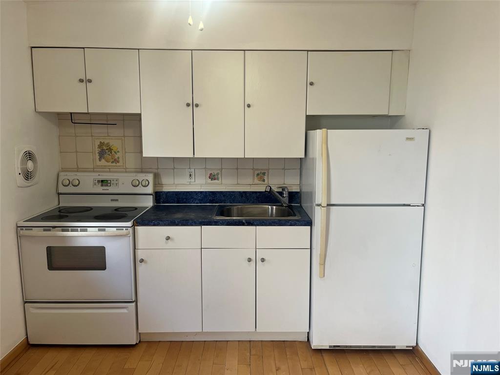201 12th Street, Unit 6 Palisades Park, NJ 07650 - Photo 8 of 19 a kitchen with cabinets appliances and wooden floor
