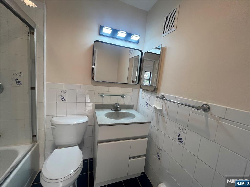 201 12th Street, Unit 6 Palisades Park, NJ 07650 - Photo 9 of 19 a bathroom with a toilet a sink a vanity and mirror