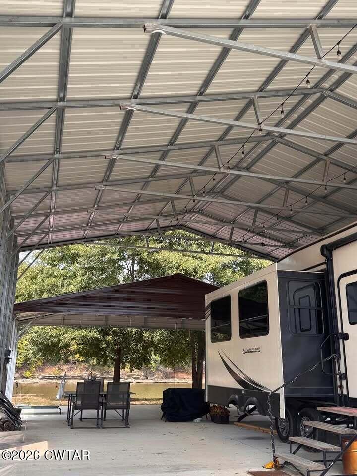 267 Dd Cove Decaturville, TN 38329 - Photo 55 of 60 a view of a patio with table and chairs under an umbrella with a small yard