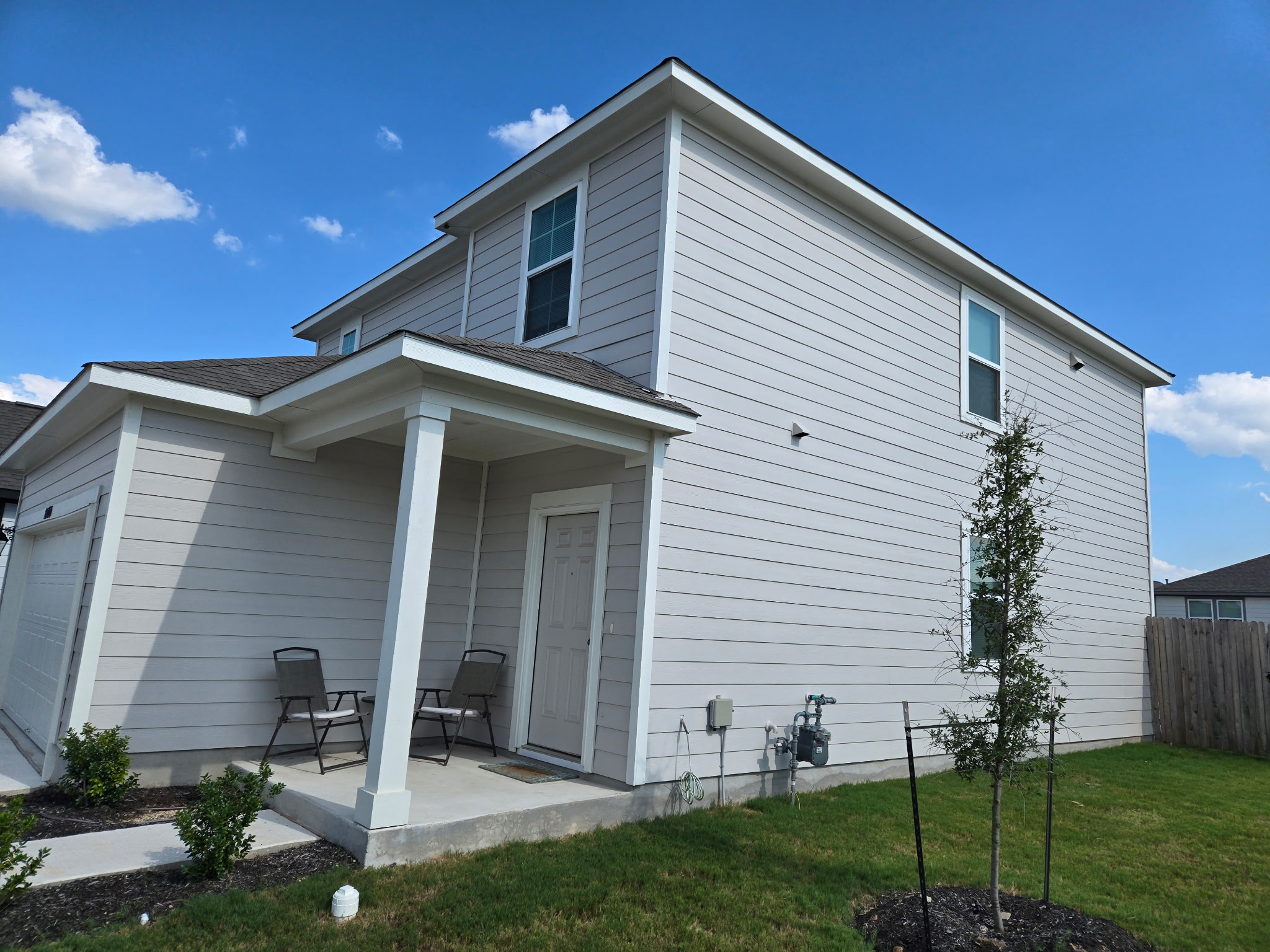 10615 Ridan Way Buda, TX 78610 - Photo 3 of 21 View of side of property featuring a garage, a shingled roof, and a patio