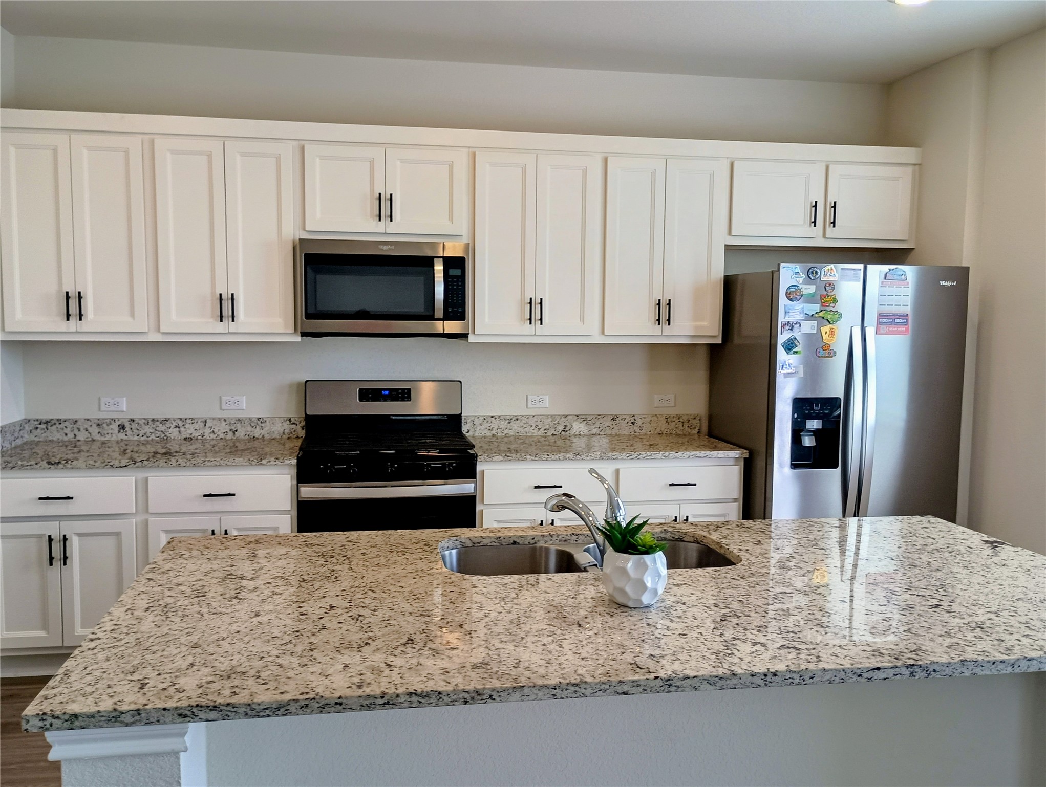 10615 Ridan Way Buda, TX 78610 - Photo 5 of 21 Kitchen featuring stainless steel appliances, light stone counters, and white cabinets
