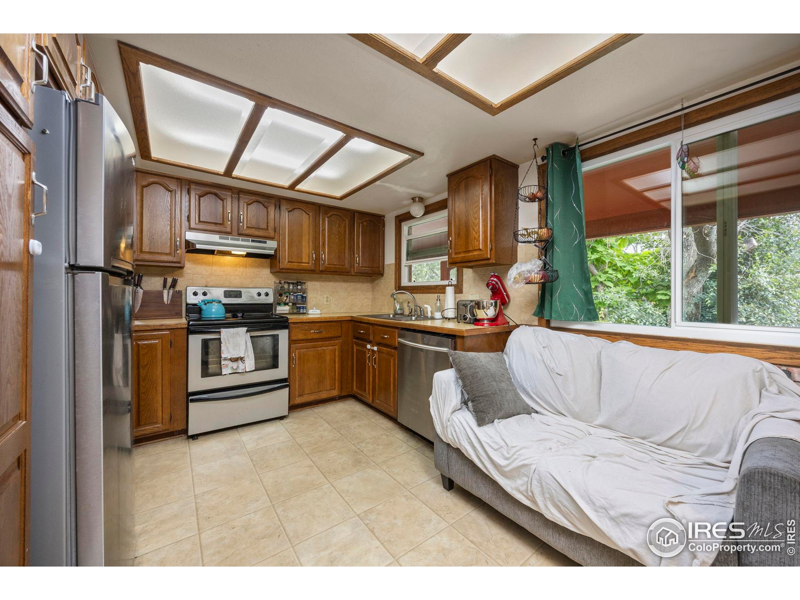 1045 Montview Road Fort Collins, CO 80521 - Photo 8 of 25 a kitchen with stainless steel appliances granite countertop a stove a sink and a refrigerator