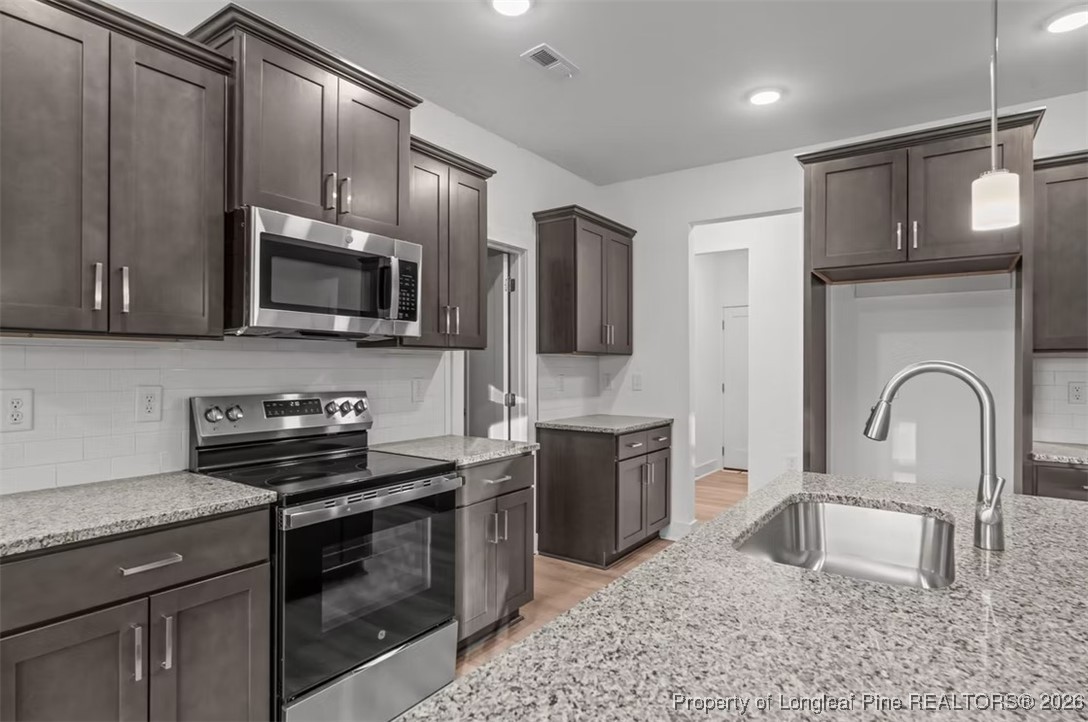 9806 Rockfish Road Raeford, NC 28376 - Photo 6 of 33 a kitchen with stainless steel appliances granite countertop a sink dishwasher a stove top oven a refrigerator with granite countertops and cabinets