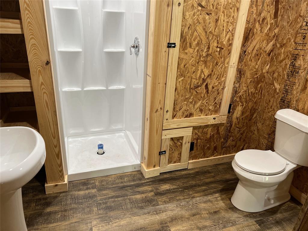 7304 Shady Lane Scurry, TX 75158 - Photo 33 of 39 Compact bathroom featuring a white pedestal sink, a white toilet, and a white one-piece shower stall with chrome fixtures