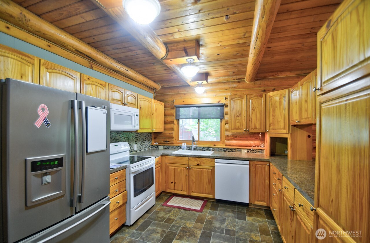 18114 Rampart Drive Southeast Yelm, WA 98597 - Photo 10 of 40 a kitchen with stainless steel appliances a refrigerator and a stove