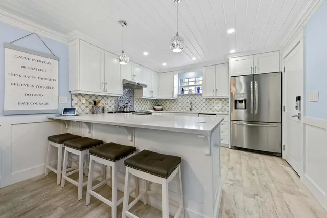 a room with stainless steel appliances kitchen island granite countertop furniture and a chandelier