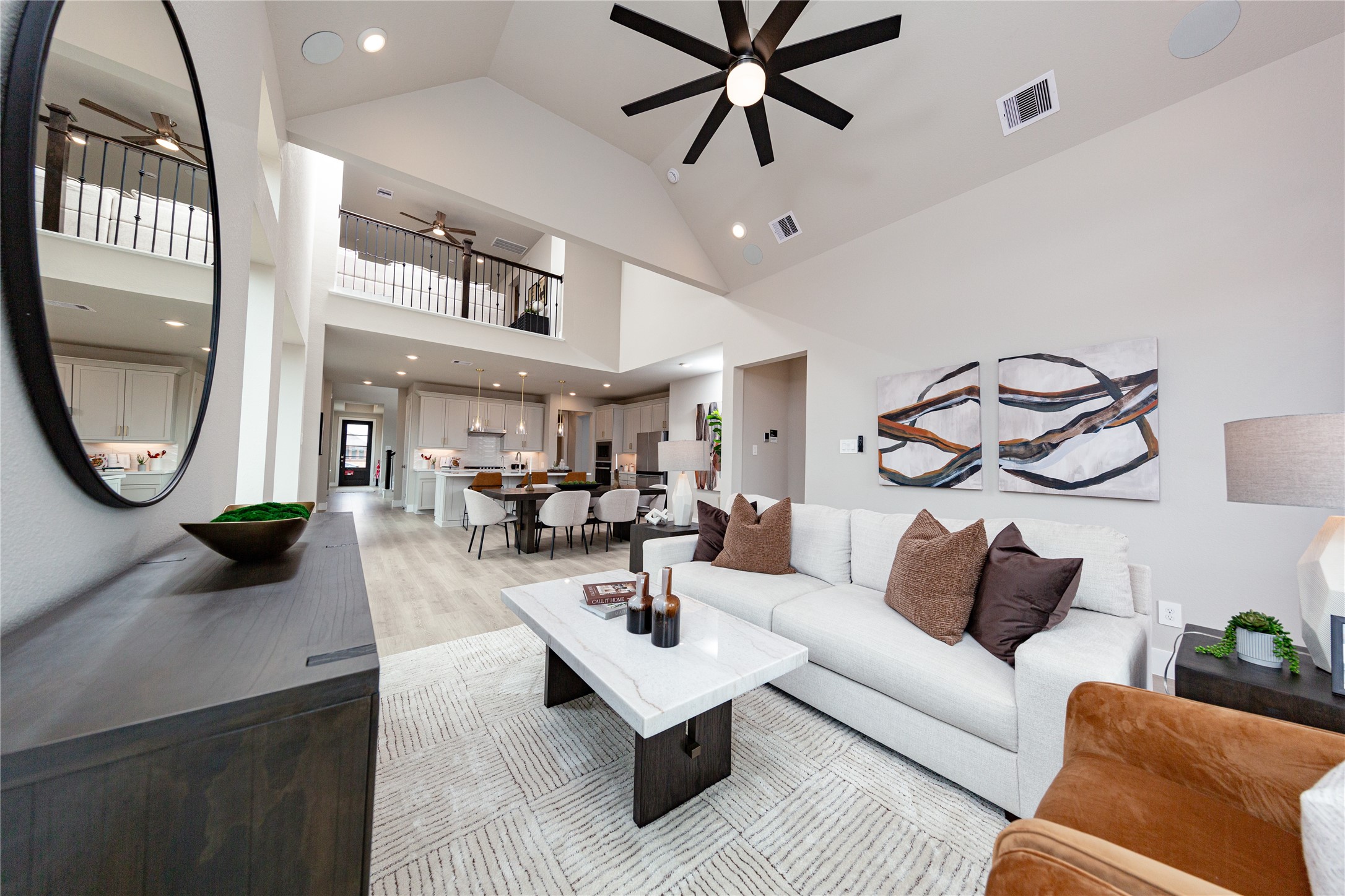 20518 Bronco Rdg Drive Tomball, TX 77377 - Photo 14 of 14 This impressive view from the great room perfectly highlights the home's spectacular open-concept living space and soaring vaulted ceilings. The expansive main level flows effortlessly from the inviting family room into the central dining area and gourmet kitchen beyond, making it an entertainer's dream. Overhead, a dramatic loft looks down onto the living area, accentuating the architectural depth, incredible height, and connected layout of this multi-level floor plan.