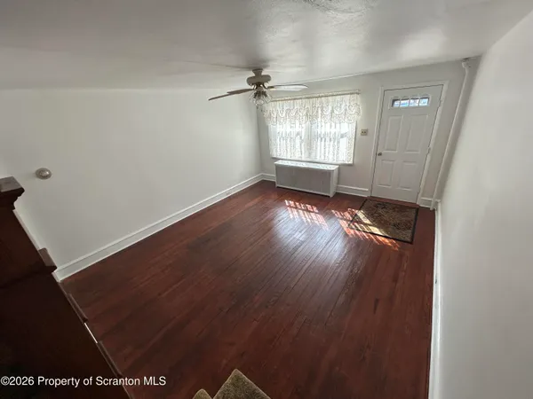wooden floor in an empty room with a window